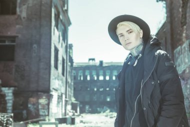 Sokakta yürüyen, açık saçlı genç bir adamın portresi. Gündelik moda, güzellik.