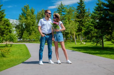 Güneşli bir yaz gününde parkta aşık mutlu genç insanlar. Yaz tatili. Aşk konsepti.