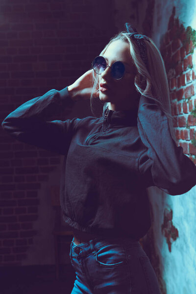 Portrait of a pretty blonde girl in round sunglasses. Beauty, fashion. Modern pin-up style. Optics.