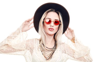 Yaz stili. Açık beyaz dantelli elbise ve güneş gözlüğü takan sarışın güzel bir kızın portresi. Beyaz arkaplanda stüdyo portresi.