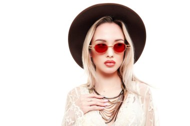 Yaz stili. Açık beyaz dantelli elbise ve güneş gözlüğü takan sarışın güzel bir kızın portresi. Beyaz arkaplanda stüdyo portresi.