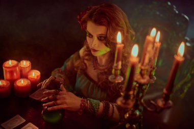 Muhteşem falcı kadın sihirli kristal küre ve tarot kartlarıyla geleceği okuyor..