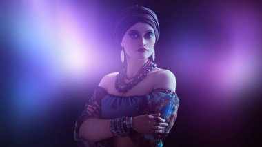 Siyah arka planda güzel bir çingene kadının portresi. Ulusal çingene kostümü, etnik. Makyaj ve başlık.