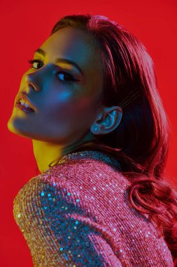 Makyaj ve makyaj malzemeleri. Renkli, mavi ve sarı ışıkta altın makyajlı muhteşem bir genç kadının portresi. Parti tarzı. Boşluğu kopyala.