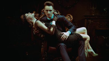 Yakışıklı bir adam ve 1920 'lerin tarzında güzel bir genç kadın. Moda giysileri, makyaj ve lüks retro tarzı saçlar..