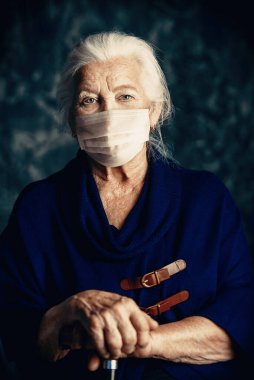 Tıbbi maskeli yaşlı bir kadının portresi. Sağlığa. Karantinaya alın. Salgın.