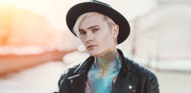 Sokakta yürüyen, açık saçlı genç bir adamın portresi. Gündelik moda, güzellik, optik.