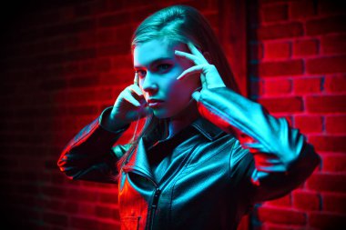 Dairenin içinde şık bir deri ceketle poz veren güzel bir kadın model. Gece kulübü partisi..