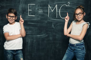 Sınıfta tahtada duran iki neşeli genç öğrenci var. Okul, eğitim konsepti.