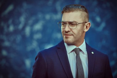 Takım elbiseli ve gözlüklü saygıdeğer olgun bir adamın portresi. İş adamı portresi. Boşluğu kopyala.