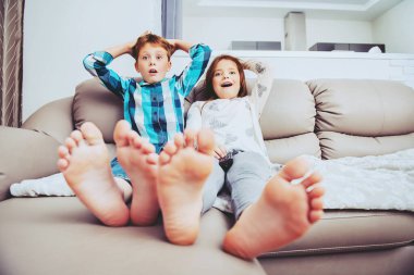 COVID-19 ve ev izolasyonu. Aile evde. Komik çocuklar karantina sırasında evde oturup televizyon izliyorlar..