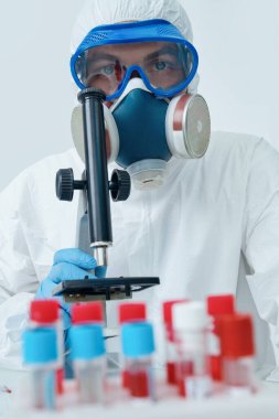 COVID-19. Doktor, mikrobiyolog, koruyucu kıyafetli bilim adamı, laboratuvarda koronavirüs üzerine bir çalışma yapıyor. Coronavirus testi.