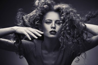 Uzun kıvırcık kızıl saçlı. Hareket muhteşem uzun saçlı güzel bir moda kız Portresi. Sarı arka plan. Uçan saç.