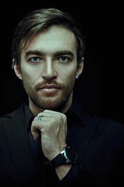 Siyah arka planda şık takım elbiseli yakışıklı bir adamın portresi. İş tarzı, iş adamı. Stüdyo çekimi. 