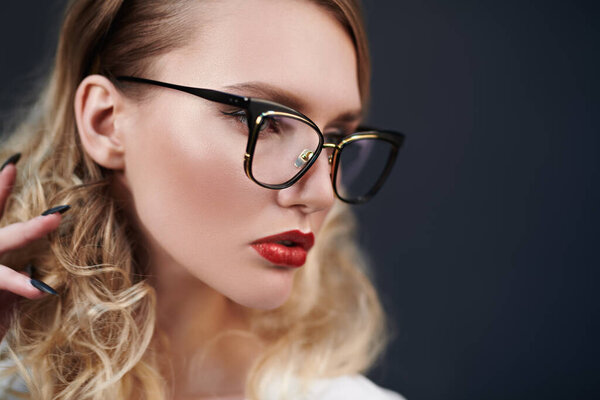 Бизнес стиль. Студийный портрет модной блондинки в элегантных очках. Оптика, очки. Копирование пространства.