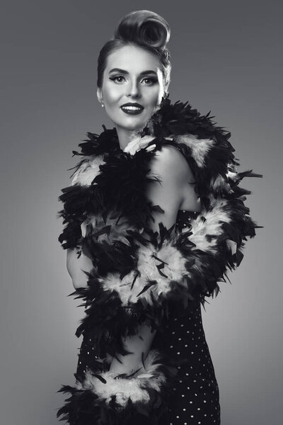 Красивая гламурная женщина в элегантном вечернем платье. Пин-ап стиль в одежде, прическах и макияже. Желтый фон. 