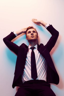 Erkek modası. Çok renkli bir takım elbise giymiş yakışıklı bir adamın portresi. İş adamı stüdyo resmi.