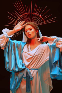 Siyah arka planda kırmızı ışıkta duran Bakire Meryem portresi. Modern din sanatı. 