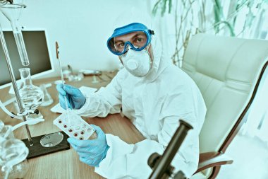 COVID-19 or SARS-CoV-2. Doctor, microbiologist, scientist in a protective suit, makes a study of coronavirus in the laboratory. Coronavirus test. clipart