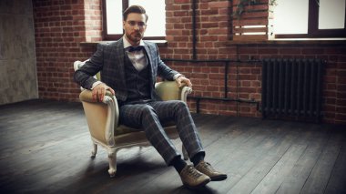 Şık takım elbiseli yakışıklı bir adamın portresi koltukta rahatça oturuyor. Başarılı bir iş adamı. Hayat güzel bir kavram.. 