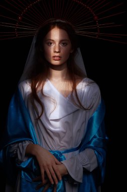 Karanlık bir arka planda ışık ışınlarıyla Bakire Meryem portresi. Modern din sanatı. Vaftiz töreni..