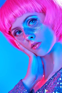 Güzellik, makyaj ve makyaj konsepti. Parlak çilleri ve parlak pembe peruğu olan çekici bir kızın portresi. Tatil ve parti tarzı.