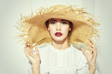 Beyaz bluz ve hasır şapkalı güzel romantik kız. Yaz sezonu. Güzellik ve kozmetik.