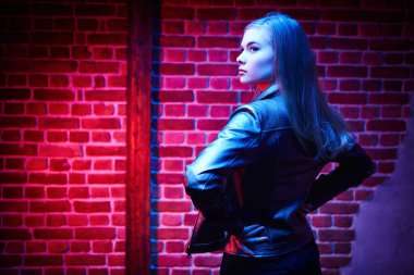 Dairenin içinde şık bir deri ceketle poz veren güzel bir kadın model. Gece kulübü partisi..