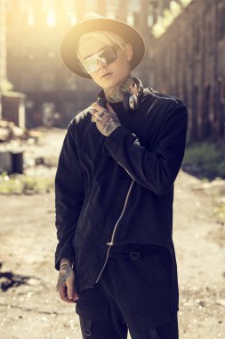 Arka bahçede poz vücudunda dövmeler ile savurgan bir genç Asyalı adam parlak bir portre. Yaz, güzellik, bodyart, dövmeler, moda.