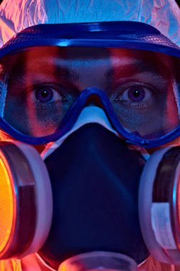 COVID-19 veya 2019-NCoV. Solunum maskesi takmış bir bilim adamının yakın plan portresi. Salgın.