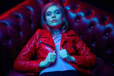 Lüks bir iç mekanda şık kırmızı deri ceketli şık bir bayan model. Gece partisi konsepti.