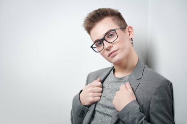 Takım elbiseli ve gözlüklü zeki bir gencin portresi. Stüdyo çekimi. Erkeklerin güzelliği.