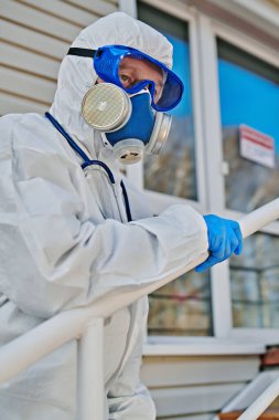 Coronavirus konsepti. Koruyucu takım elbiseli, gözlüklü ve solunum maskeli acil servis doktorunun portresi..