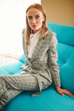 Güzel, modern iş kadını evinde kanepede dinleniyor. Modern iç mekan ve mobilya.