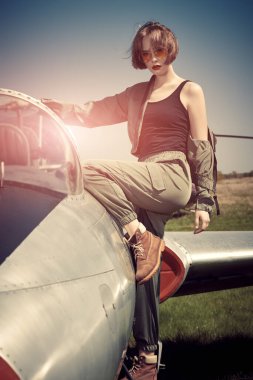 Güzel bir kız pilotun portresi havaalanındaki savaş uçağında oturuyor.. 