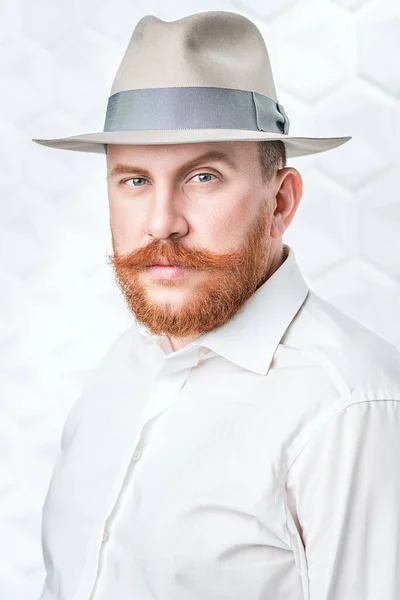 A portrait of a redhead man posing in the studio over the white background. Men's beauty, fashion, style.