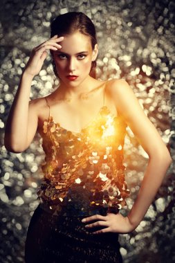 Makyaj ve makyaj malzemeleri. Işıl ışıl gümüş bir arka planda altın makyajlı muhteşem bir genç kadının portresi. Parti biçimi.