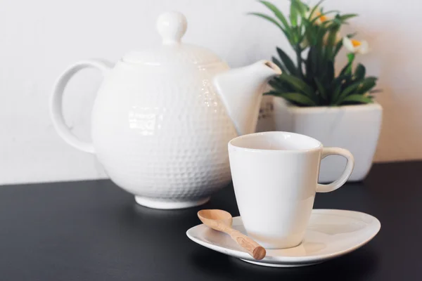 Tasse à café avec pichet sur table noire contre béton blanc wa — Photo
