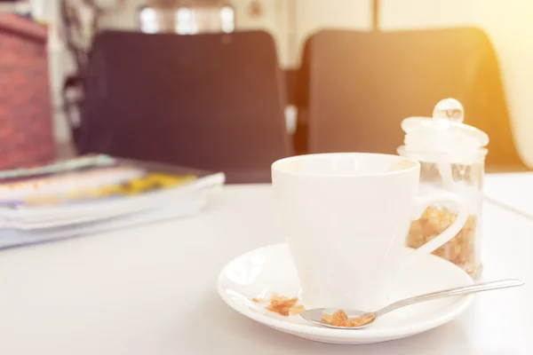 Kopp kaffe och socker med tidningen på vitt trä bord i caf — Stockfoto