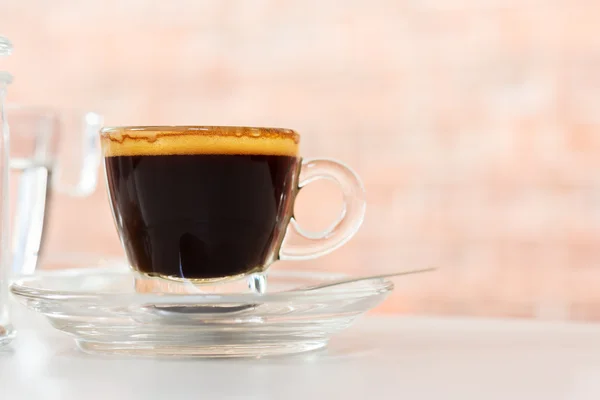 Une tasse de café. Espresso chaud avec crème dorée sur table blanche au café . — Photo