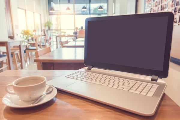 Kaffee mit Laptop auf Holztisch im Café. — Stockfoto