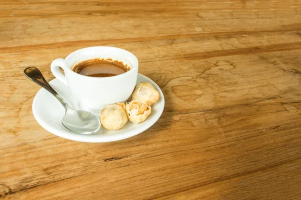 Bílý šálek kávy na hnědé dřevo stůl v café s kopií prostor — Stock fotografie