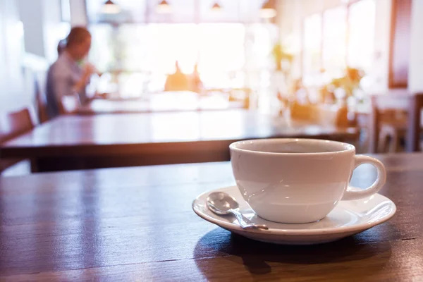 Kuppi kahvia pöydällä kahvilassa — kuvapankkivalokuva