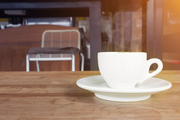 Xícara de café com fumaça na mesa de madeira no café . — Fotografia de Stock