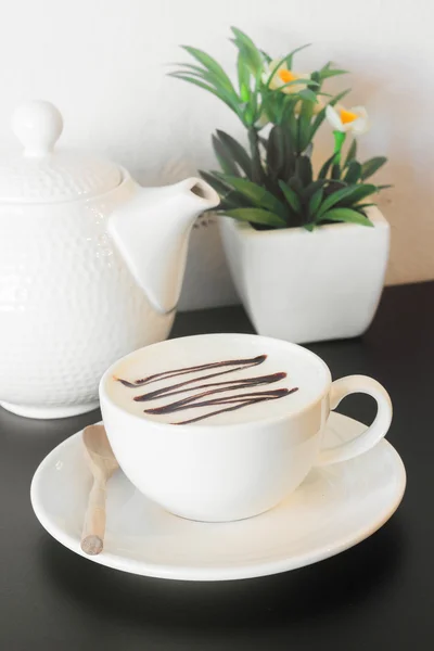 Kaffekopp med tillbringare på svart bord mot vita konkreta wa — Stockfoto