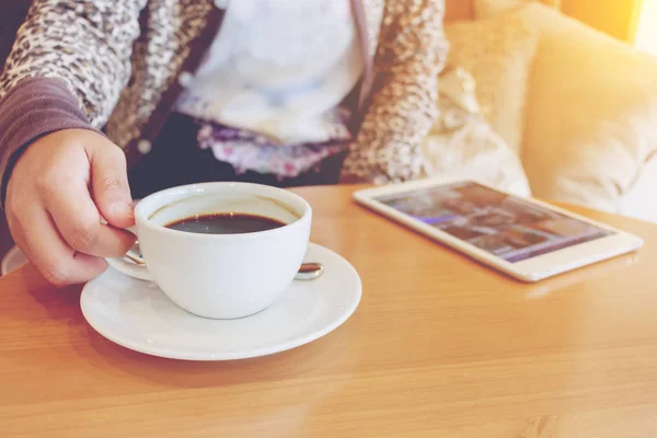 Asiatin benutzt Tablet-Computer im Café und trinkt Kaffee. — Stockfoto