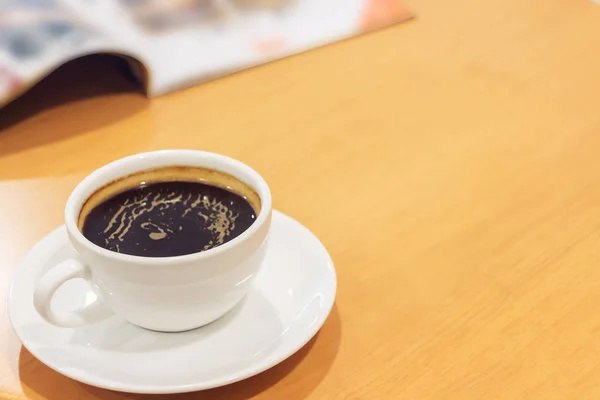 木のテーブルに雑誌とコーヒーの白いカップ. — ストック写真