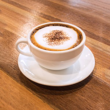 Tatlı beyaz fincan kahve ahşap masa üzerinde.