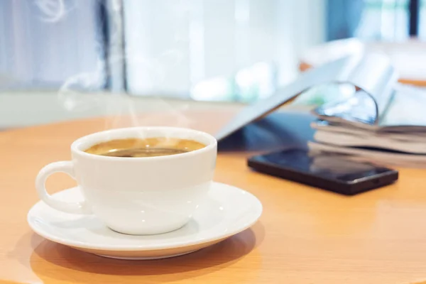 White cup of coffee with magazine and tablet computer on wood ta — Stock Photo, Image