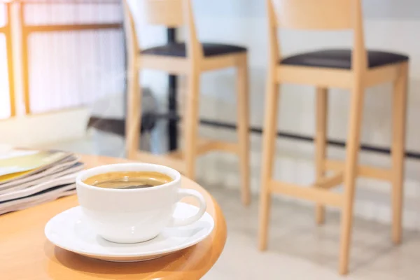 Weiße Tasse Kaffee mit Magazin auf Holztisch. — Stockfoto